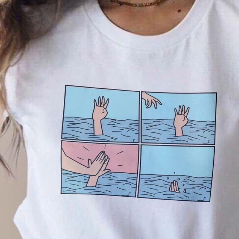 White shirt with a four-picture collage of a drawing with a person drowning; only a palm visible above the blue water, and somebody else appears to be reaching to help only to give them a high five.