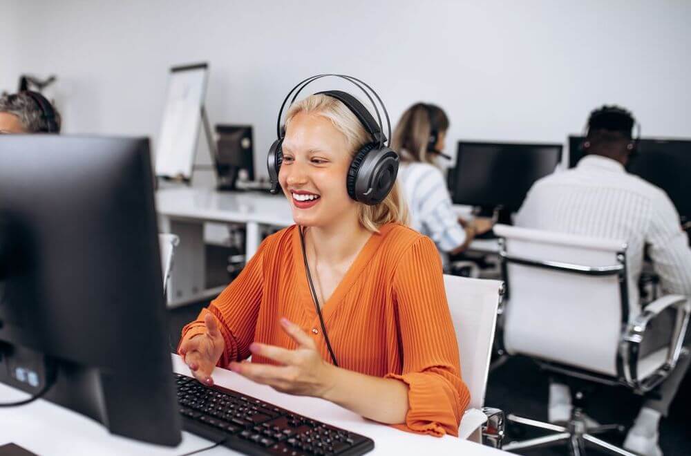 Woman working in a call center, happily guiding her customers through the phone.