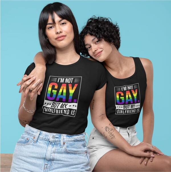 Models holding hands and posing in custom t-shirts with the text “I’m not gay. But my girlfriend is.” printed on the front.