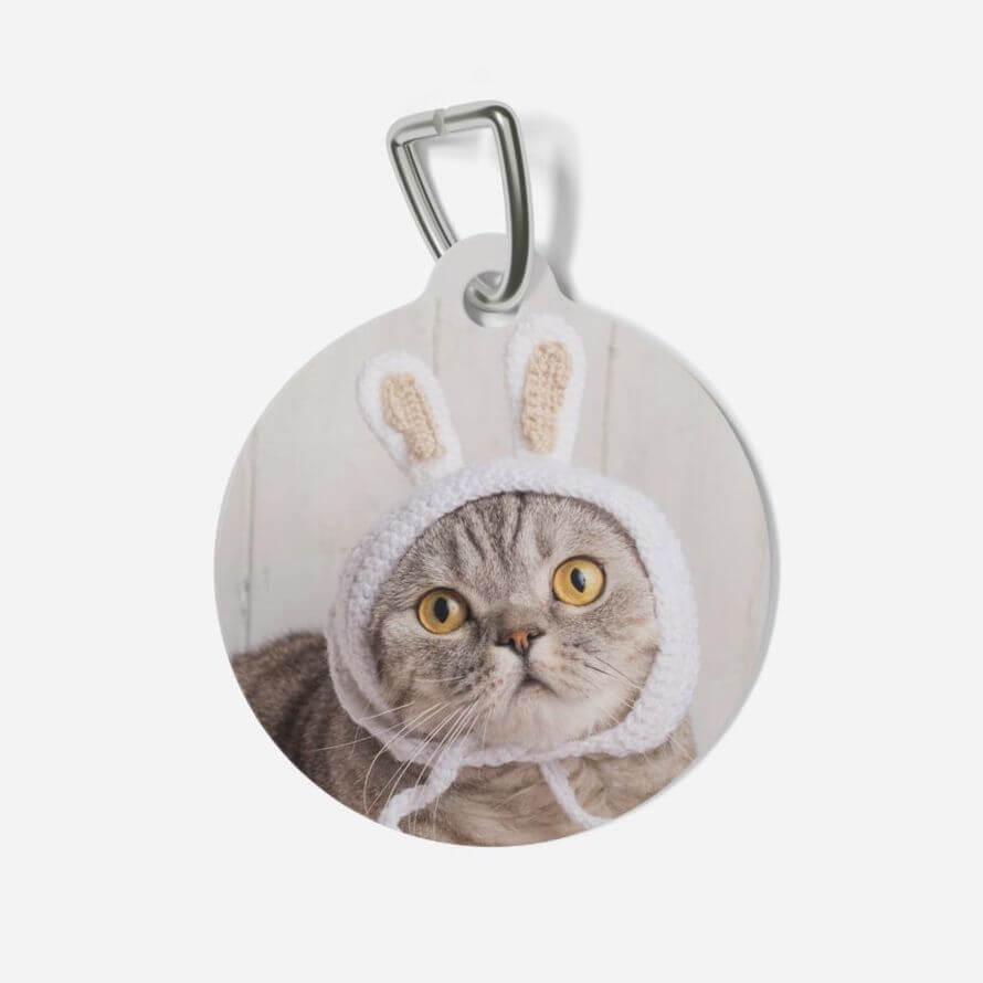 A custom photo pet tag featuring an adorable grey cat wearing a crocheted bunny ear hat printed on it.