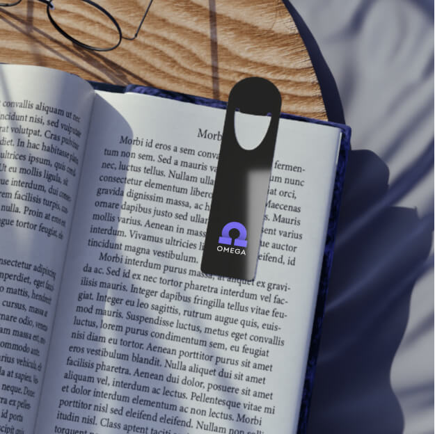 Top view of an open book with a black bookmark that says “Omega” and has the symbol of the last letter of the Greek alphabet