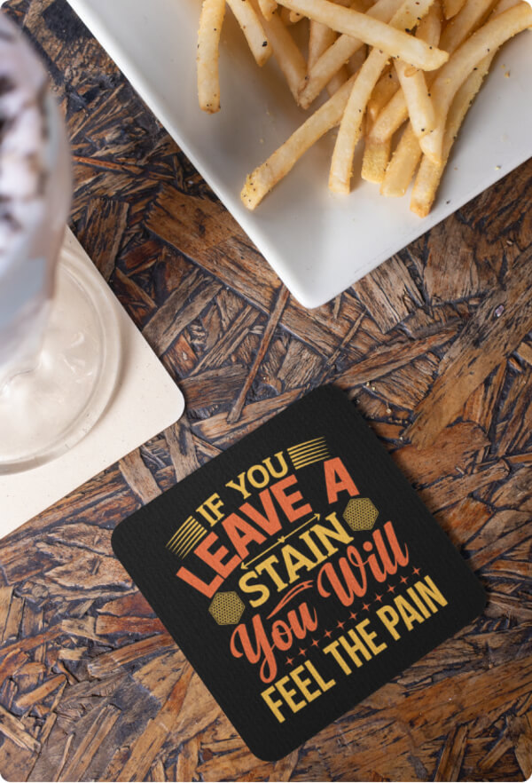 Custom coaster with the text “If you leave a stain, you will feel the pain” next to a plate of fries.