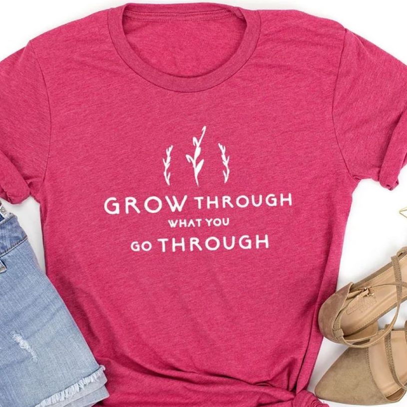 Fuchsia t-shirt with an inspirational quote in white lettering, saying, “Grow through what you go through.”