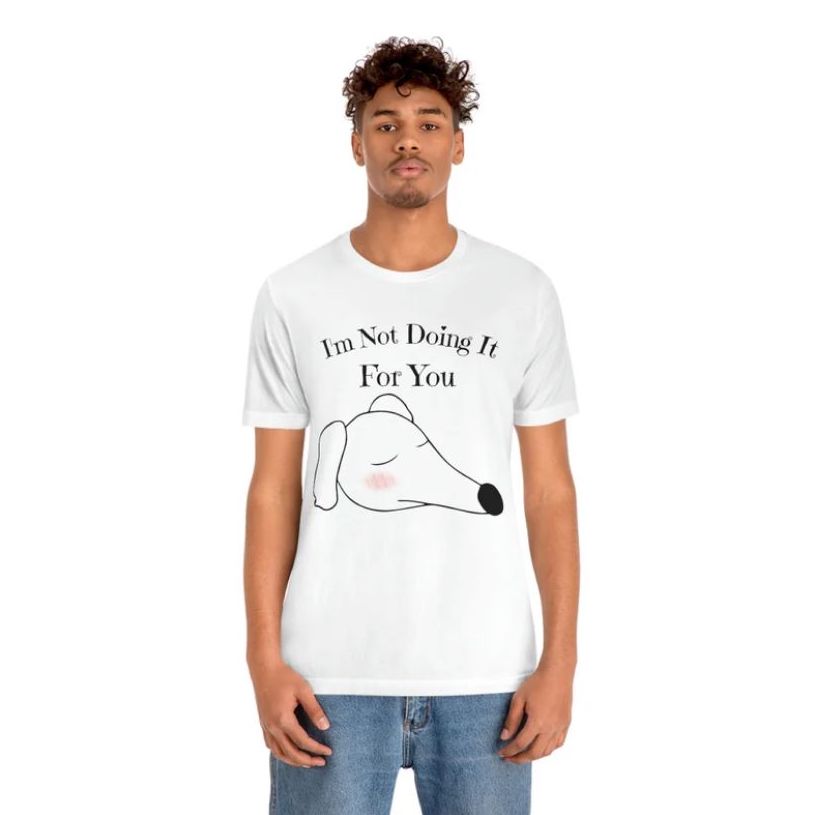 A man wearing a white t-shirt with a drawing of a big cartoon dog's head with pink cheeks and the words “I'm not doing it for you” above it.
