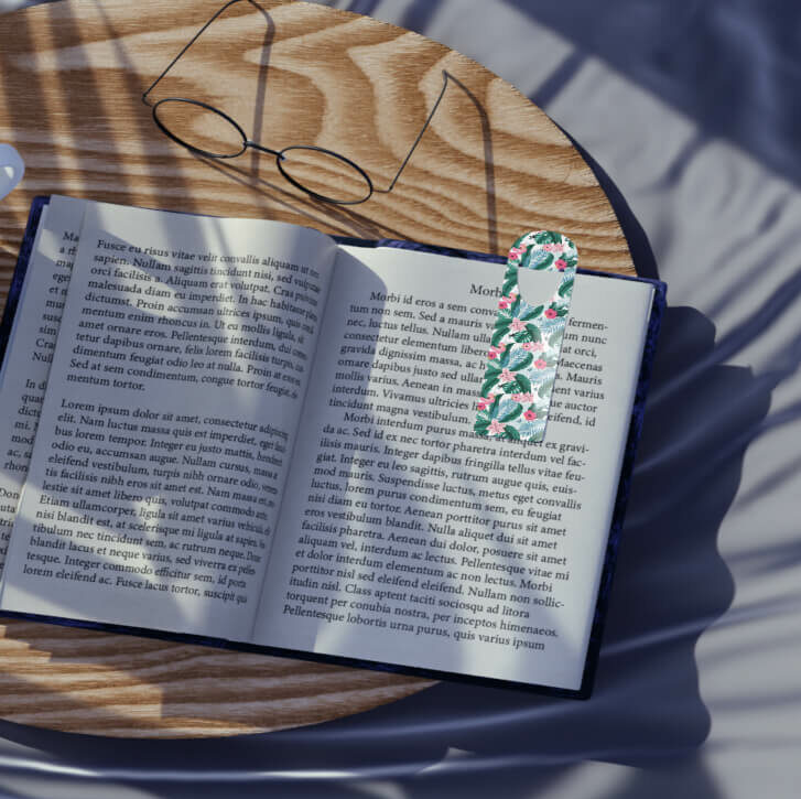 Top view of an open book with a bookmark customized with a tropical pattern