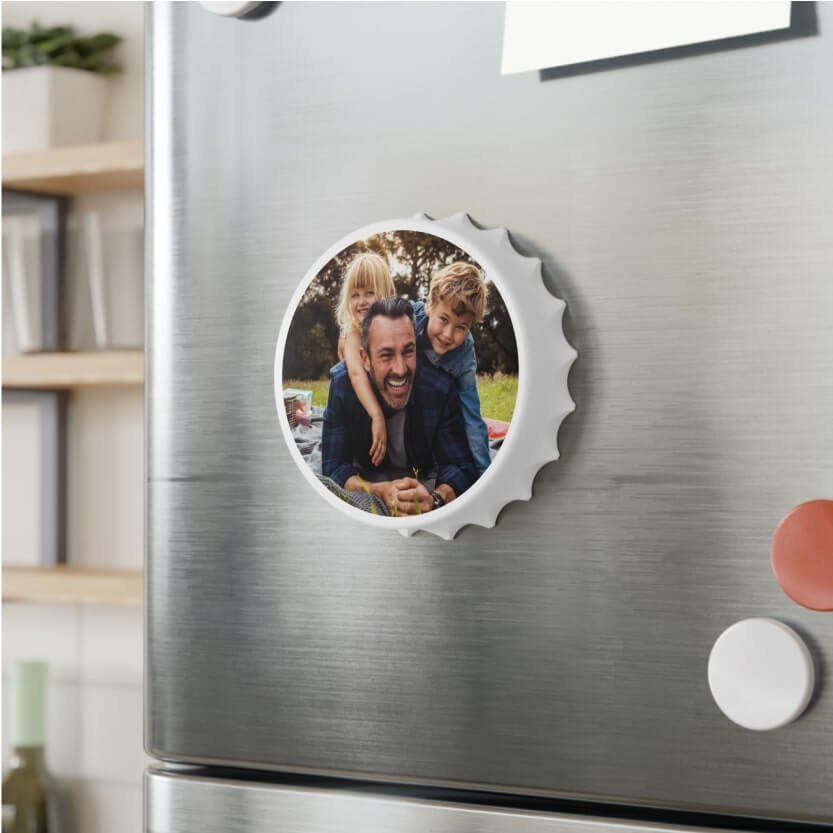 An image of a custom bottle opener with a printed picture, hanging on a refrigerator.
