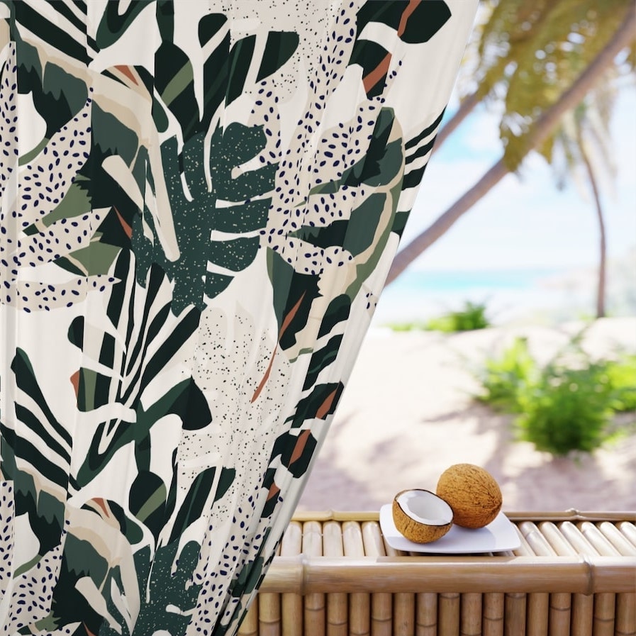 Custom curtain close-up with a printed design of rainforest leaf patterns framing a warm beach resort.