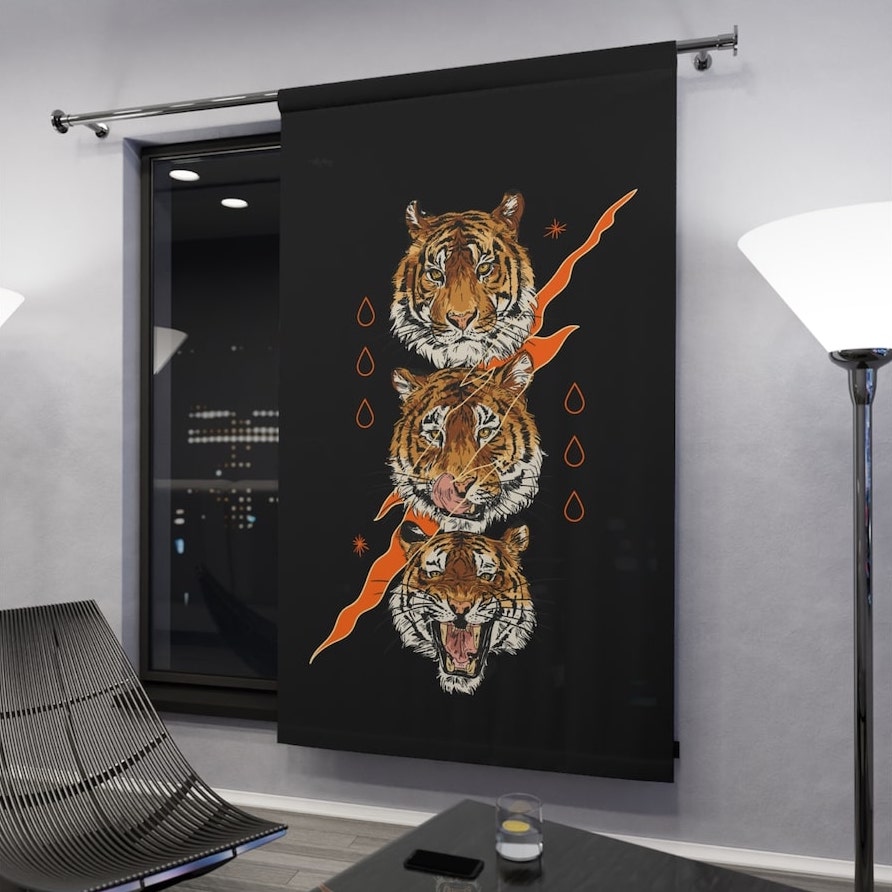 Window-length interior custom curtain installation with a stylized graphic design of tiger heads on a black background.