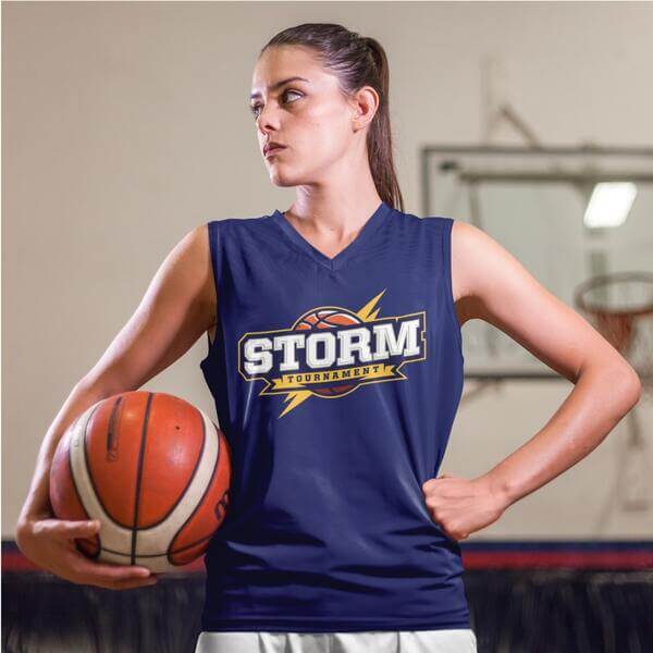 An image of a woman basketball player wearing a dark blue custom team jersey with a logo in front.