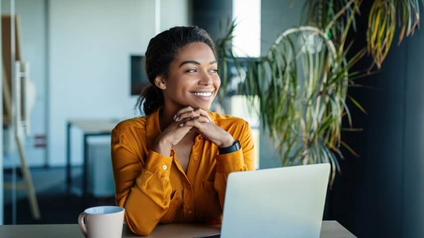 Woman smiling in front of her laptop.