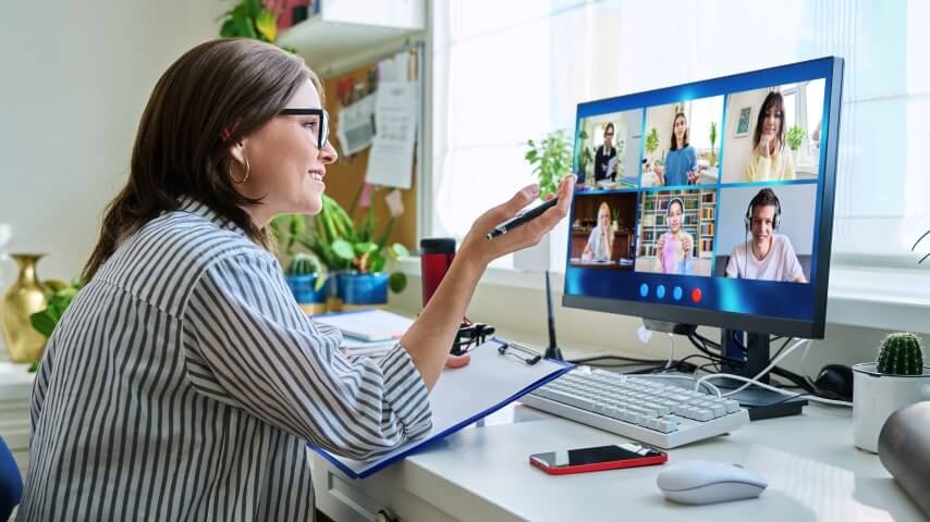 Woman tutoring multiple online students through a video call.