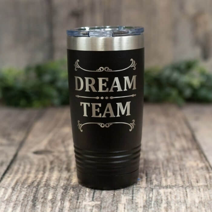 Black tumbler cup with silver lettering saying “Dream team.”