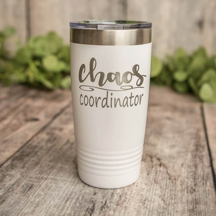 White tumbler with silver lettering saying “Chaos coordinator.”