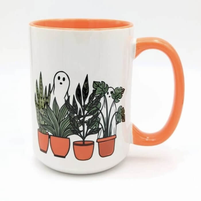 Orange accent mug with a design of two ghosts hiding behind a row of potted house plants.