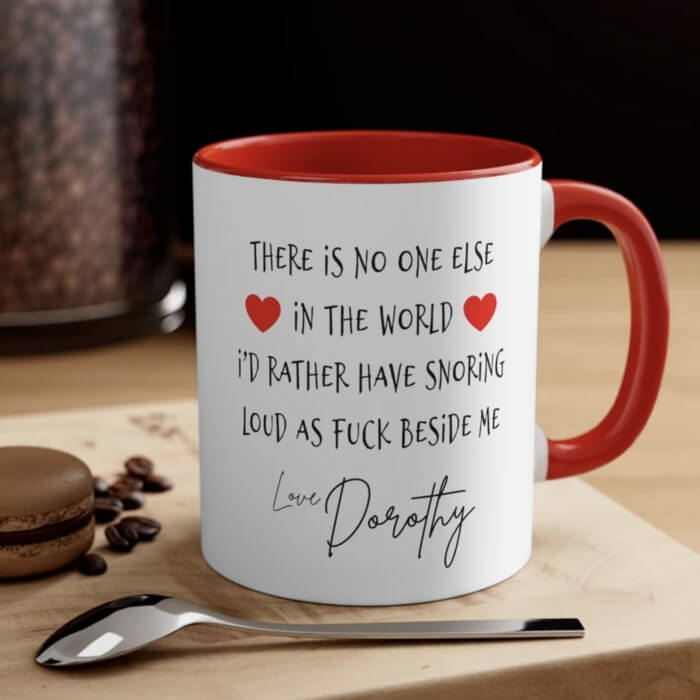 Red accent mug with the text “There is no one else in the world I'd rather have snoring loud as F beside me. Love, Dorothy.”