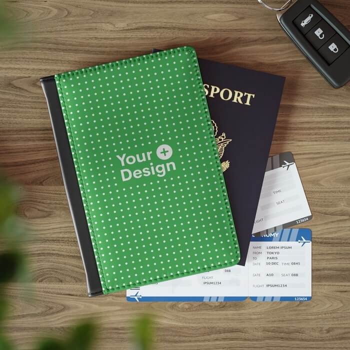 A rustic wooden table, on which rests an array of travel tickets and a passport, accentuated by a passport cover featuring an all-over print in green and bold white lettering saying 'Your Design'