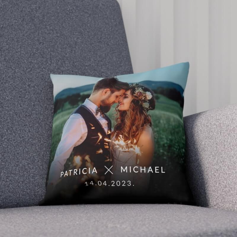 An image of a custom pillow laying on a sofa with a wedding picture print and date.
