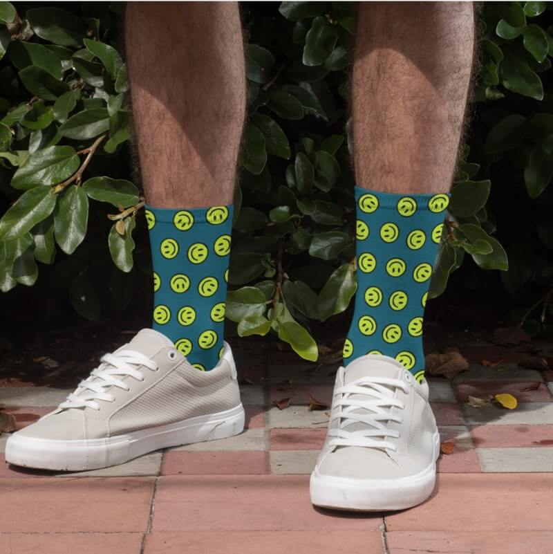 An image of a man wearing custom socks with an illustrated smiley print.
