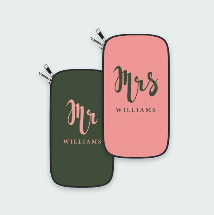 Two personalized passport holder printed in salmon pink and olive green with lettering that say Mrs Williams and Mr Williams