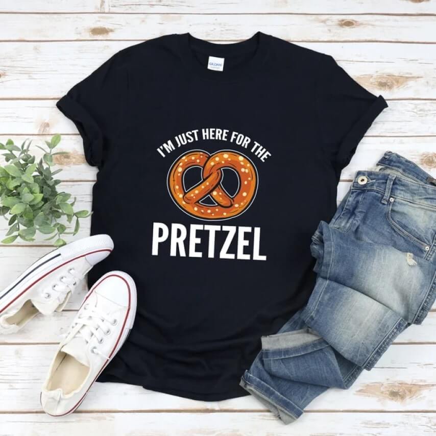 Black Oktoberfest shirt with an image of a pretzel and the text “I'm just here for the pretzel.”