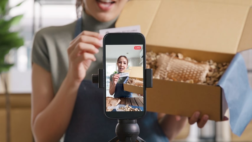 Woman filming an Instagram Reel, showcasing her product packaging and promoting the product.