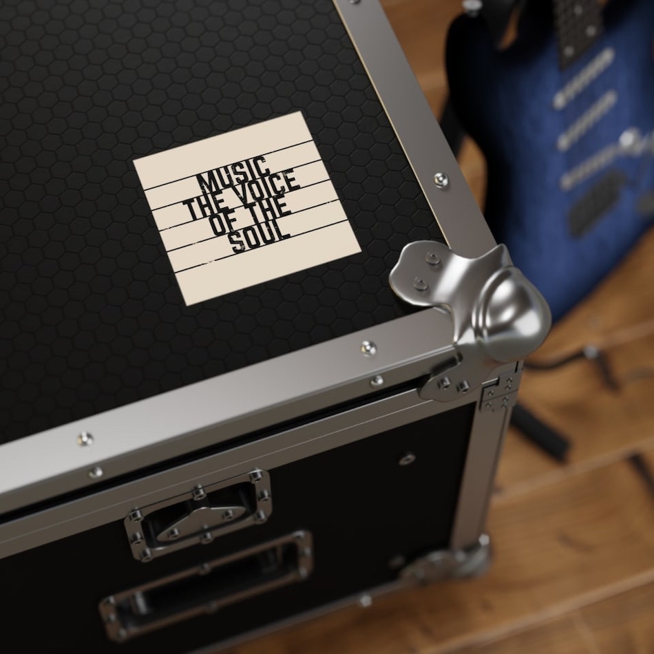 Square sticker on a black suitcase with the text “Music – the voice of the soul.”