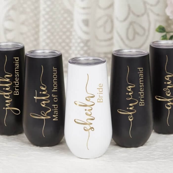 A set of wine tumblers with captions like “Sheila: Bride,” “Katie: Maid of honor,” “Olivia: Bridesmaid.”