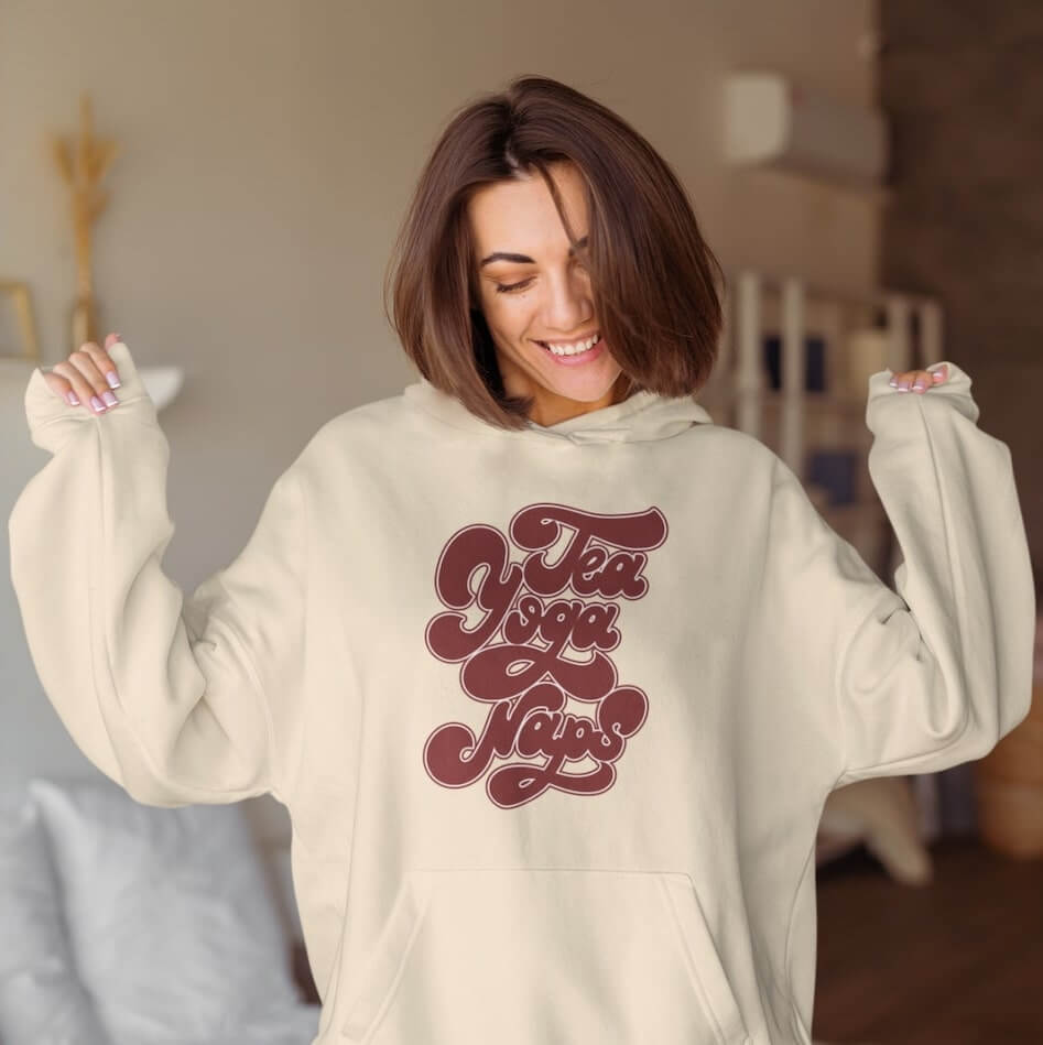 An image of a woman wearing a light-brown custom hoodie with text on it.