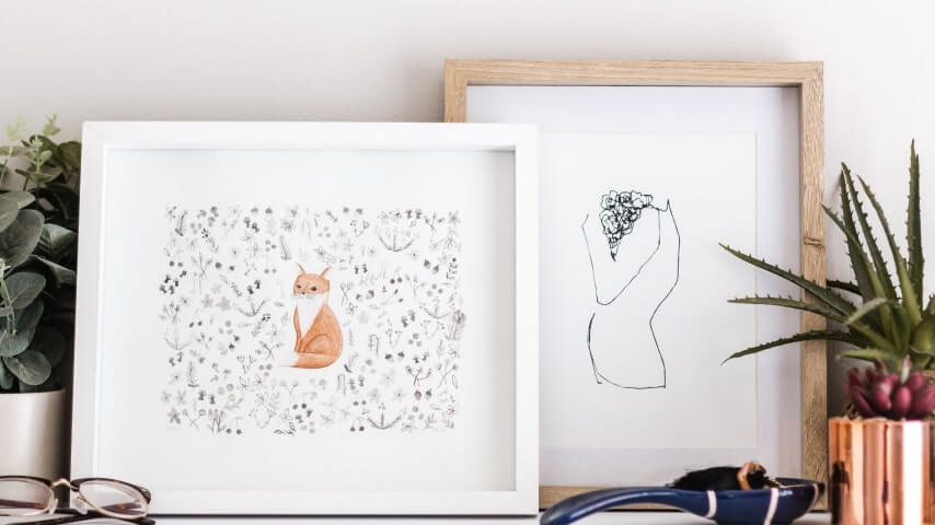 Two framed canvas posters – one with a design of an abstract woman's silhouette and the other with a design of a cute fox surrounded by flowers.
