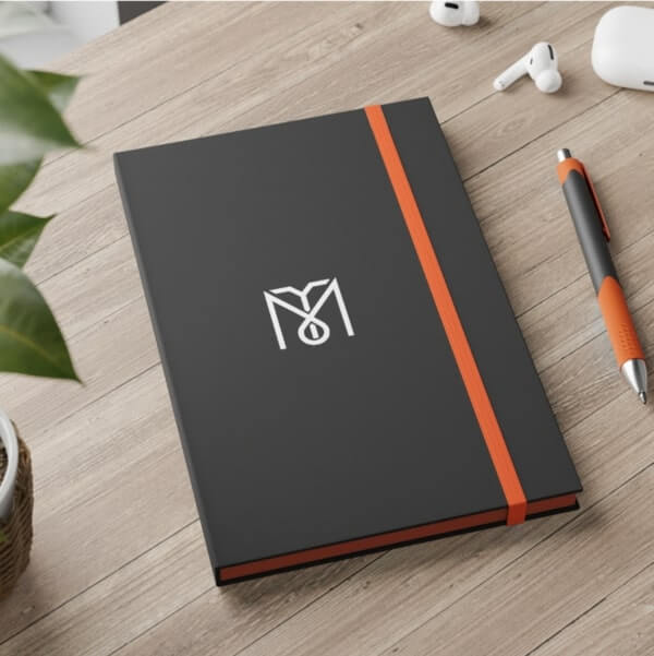Black notebook with an abstract white custom logo on the front cover.