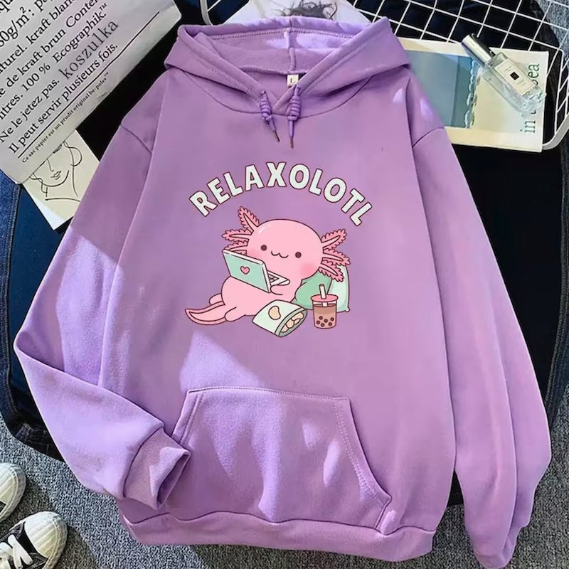 Lilac hoodie with a cartoon axolotl lying on a pillow with a laptop and snacks, with the text above it saying “Relaxolotl.”