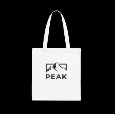 White tote bag with a minimalistic logo of mountains and the company name “Peak” underneath.