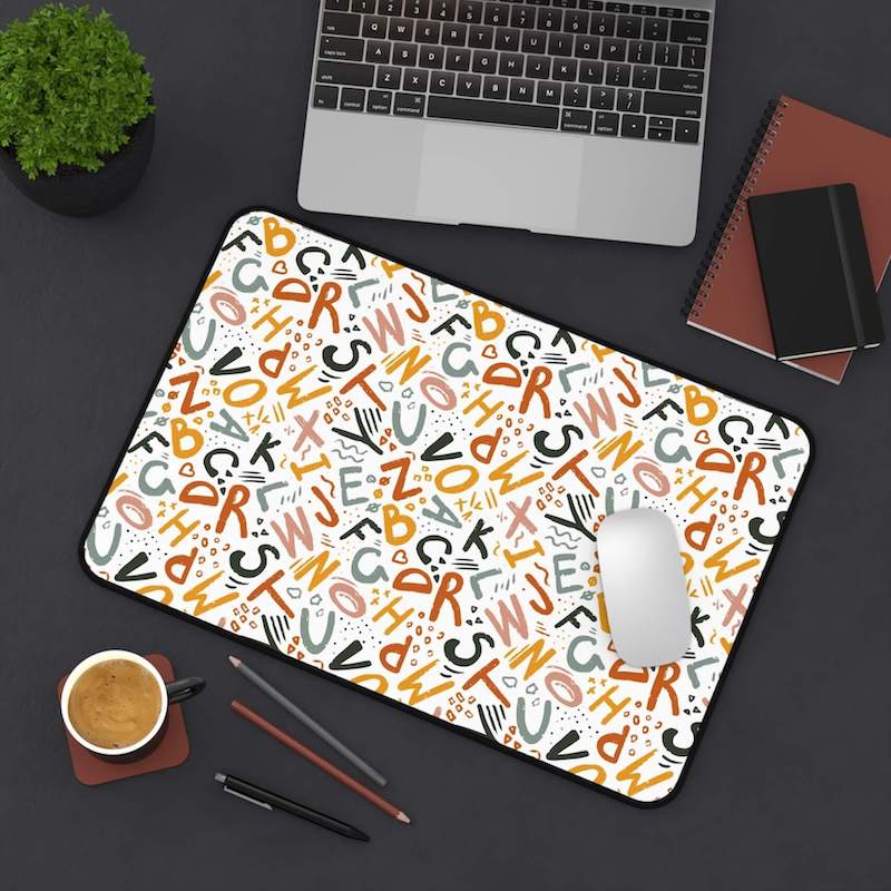 A desk mat with a creative back-to-school pattern consisting of colorful letters.