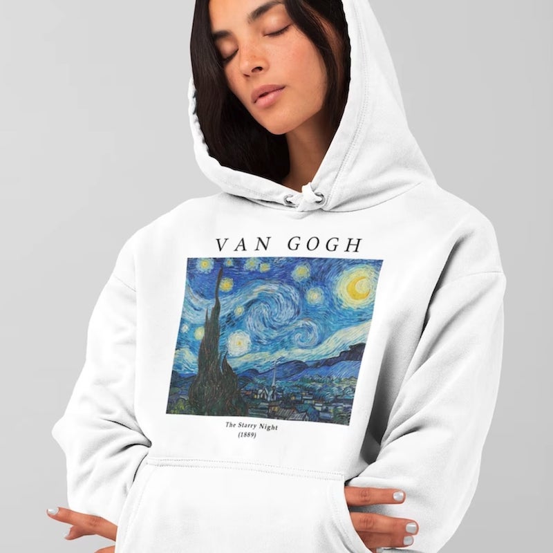 Woman wearing a white hoodie with an image of Vincent Van Gogh's “The Starry Night.”