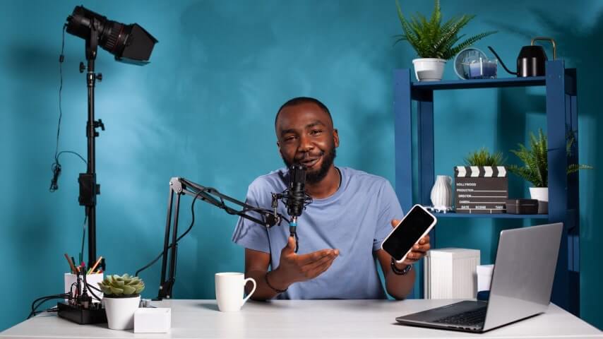 A man creating sponsored video content in a studio with cameras and a microphone.