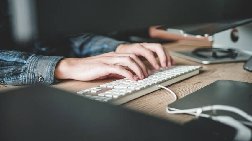 Flip Websites Person sitting at a desk and typing on a keyboard.