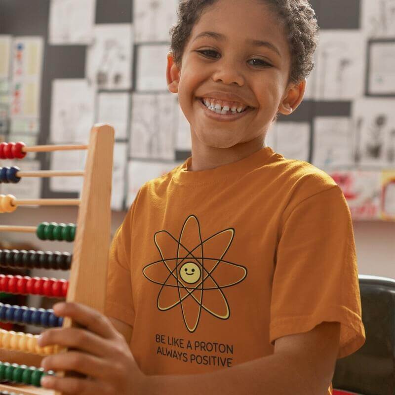 A photo of a child smiling and wearing a custom illustrated t-shirt.