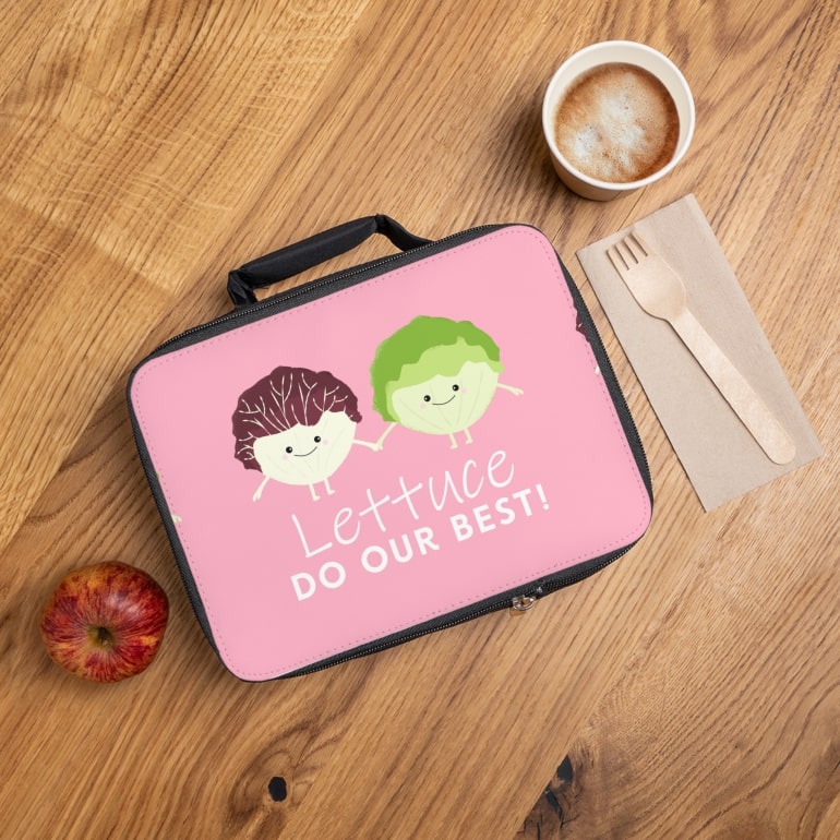 A personalized lunch bag with lettuce illustrations and text, placed on a wooden table.
