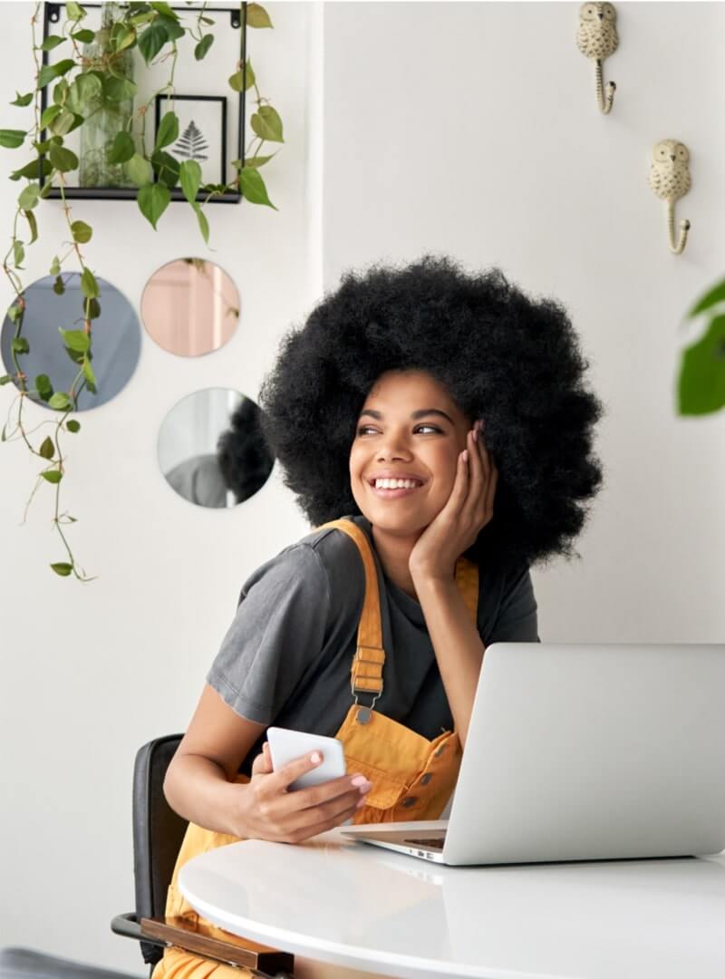 Start POD With Printify A smiling woman holding her phone and looking into the distance.