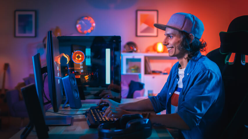 An image of a smiling man at a computer, representing an ideal customer for the video games niche.