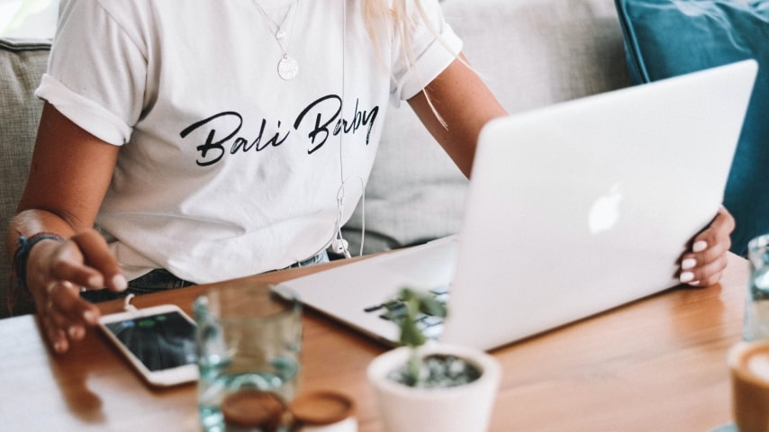 A woman sitting next to the laptop.