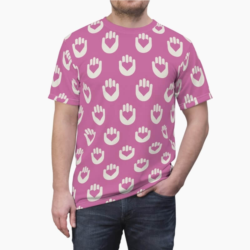 A man wearing a pink t-shirt with an AOP pattern of white hands holding heart symbols.