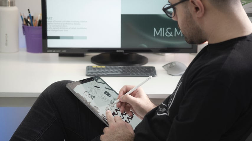 A person doing graphic design images on a tablet.