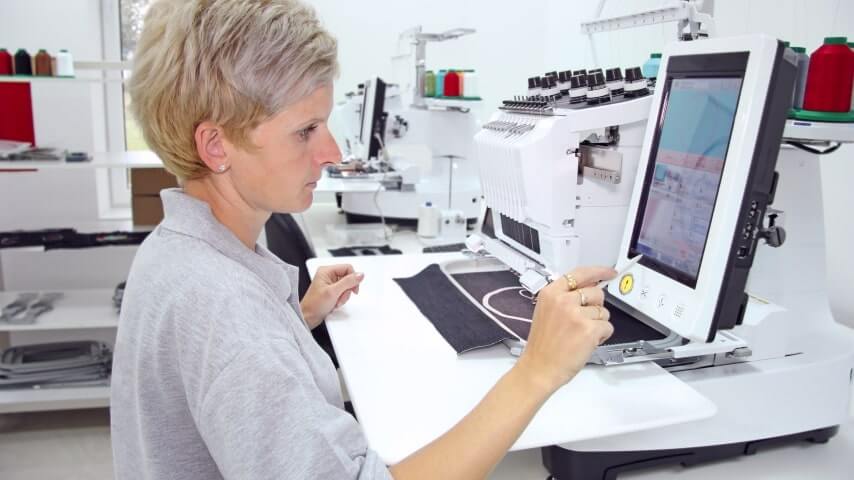 A woman using embroidery digitizing software.