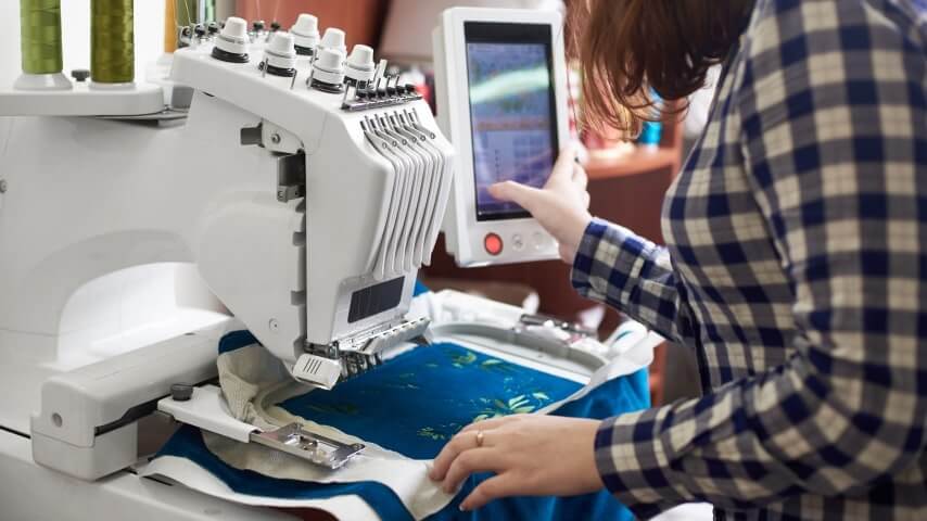 A woman working with an embroidery machine.