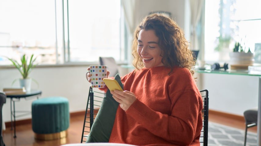 A woman using her phone to monitor her Shopify marketing efforts.