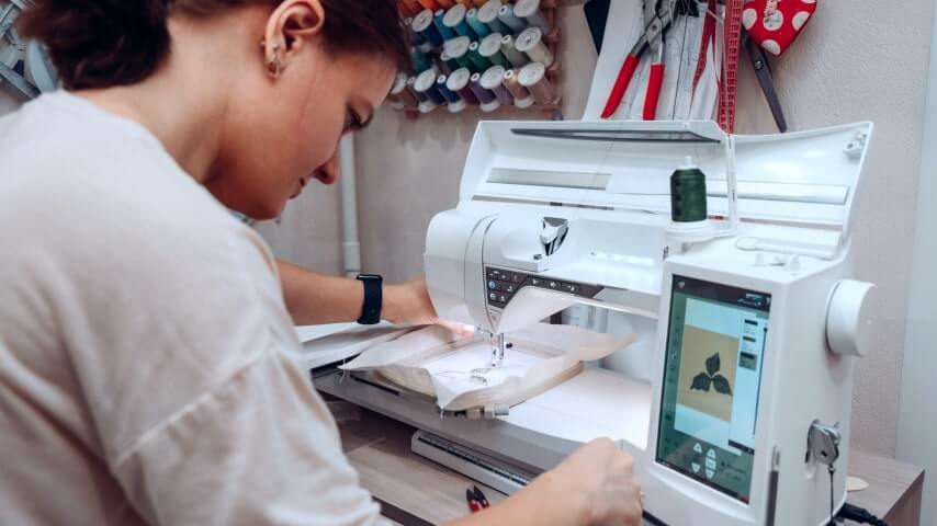 A woman selecting embroidery stitch type and direction.