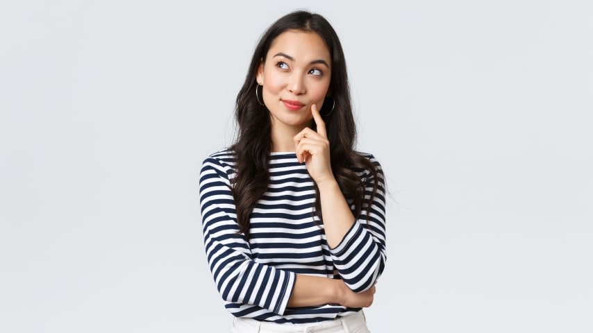 A woman standing with a thoughtful expression on her face.