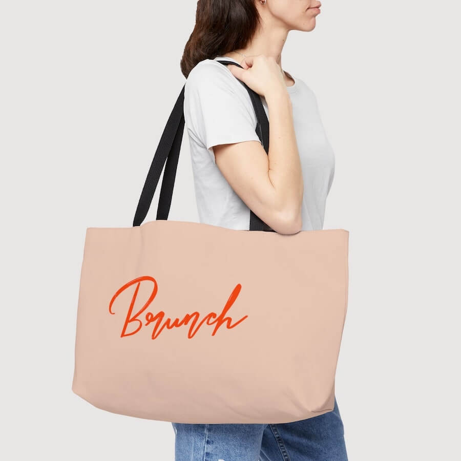 A woman with a beige shopping tote bag with the word “Brunch” printed on it.
