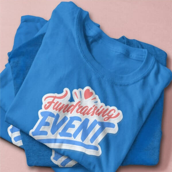 A stack of blue bulk t-shirts with the text “Fundraising Event” printed on them.